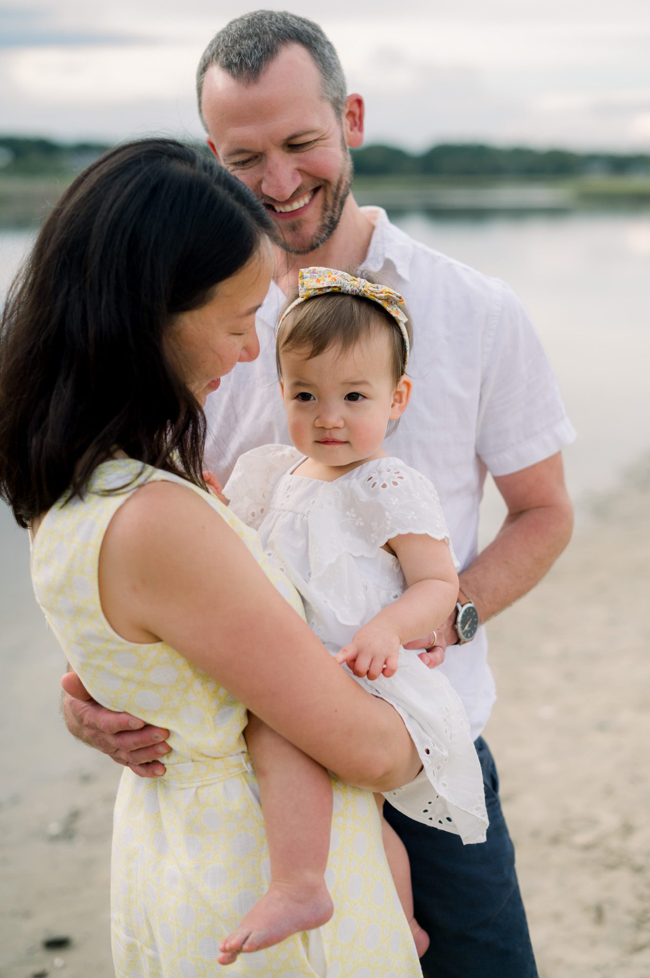 Close up of Mom & Dad holding baby girl at the beach in Southern Maine