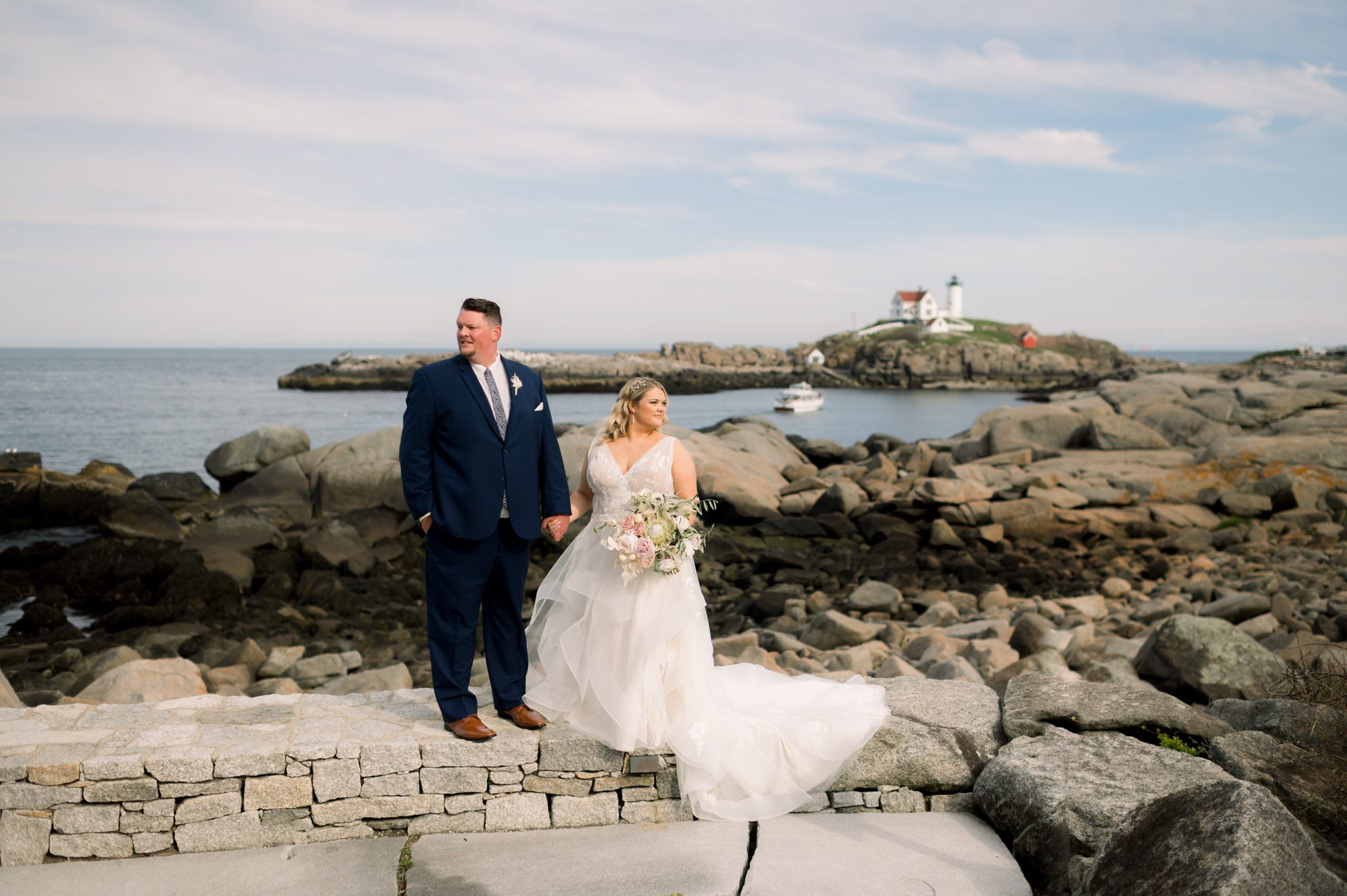 Bride & Groom holding hands with nubble Lighthouse in background at Viewpoint Hotel in York Maine.