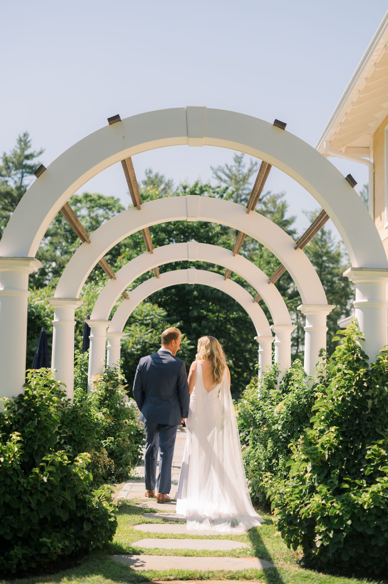 Bride & groom walking through an archway in York Maine Wedding