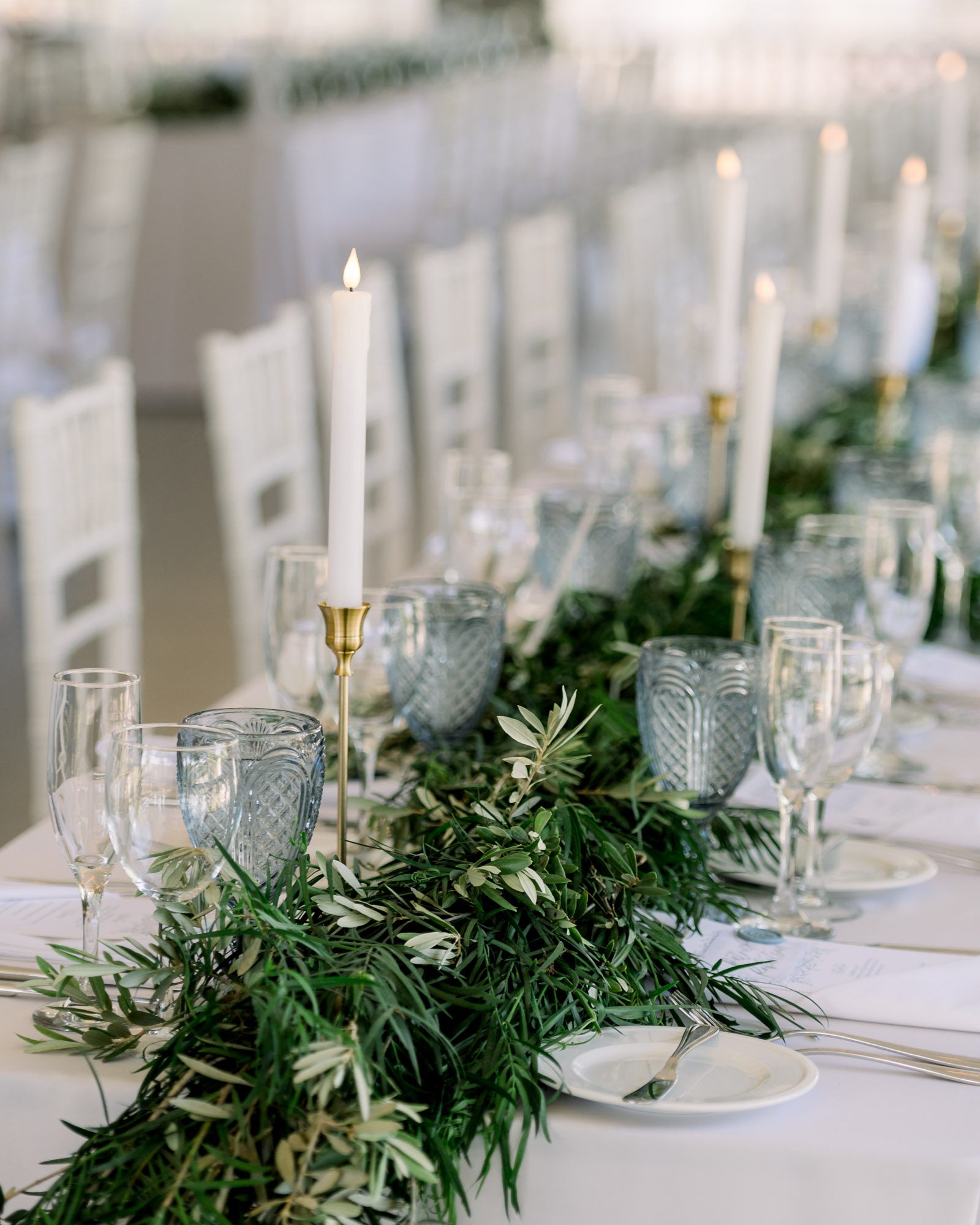 Maine wedding photographer Casey Durgin photographs York Golf & Tennis club wedding. Wedding design with blue glasses, white pillar candles , white florals, and greenery. florals.