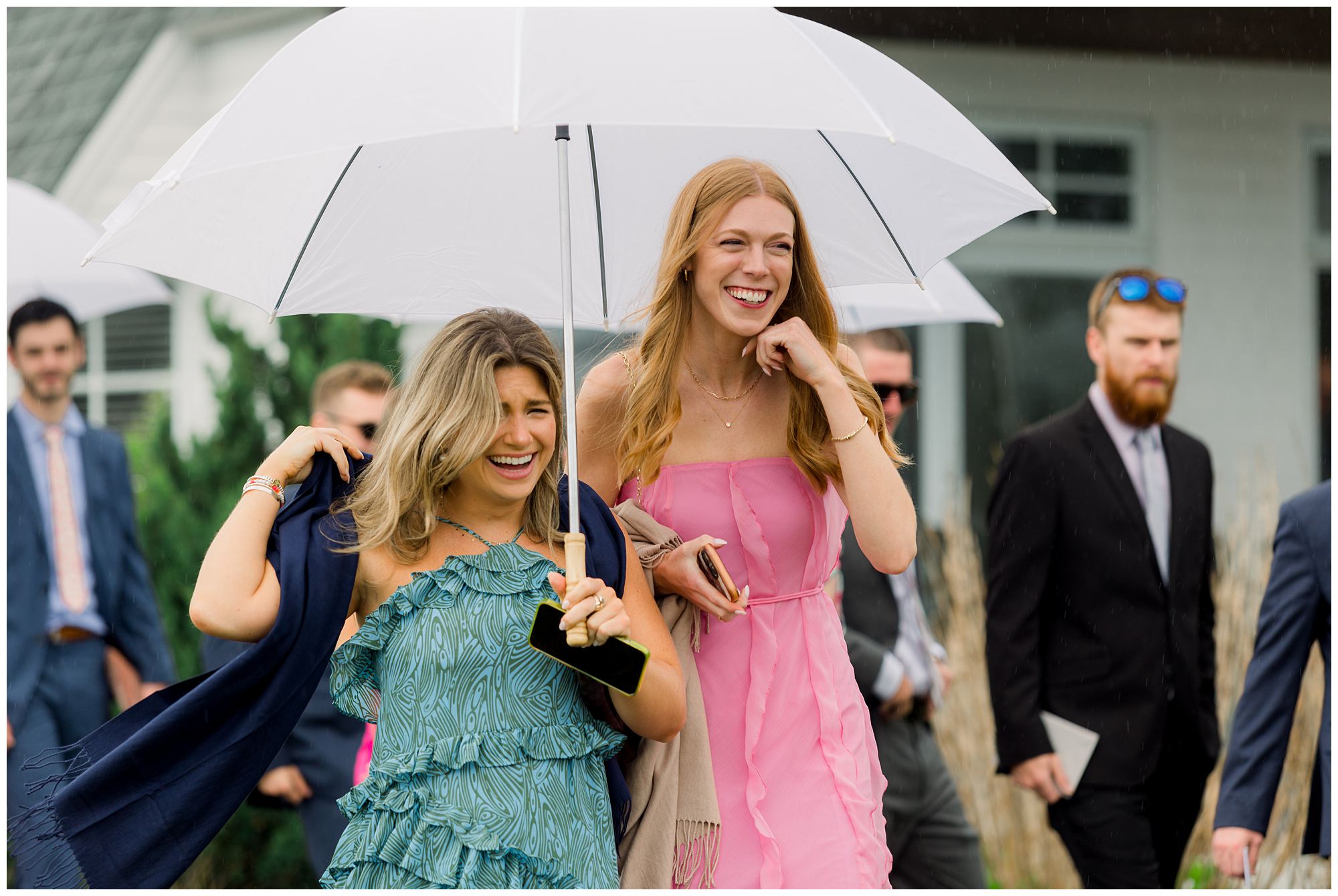 rainy day wedding candids at Viewpoint hotel in York Maine. Wedding Party walking with umbrellas.