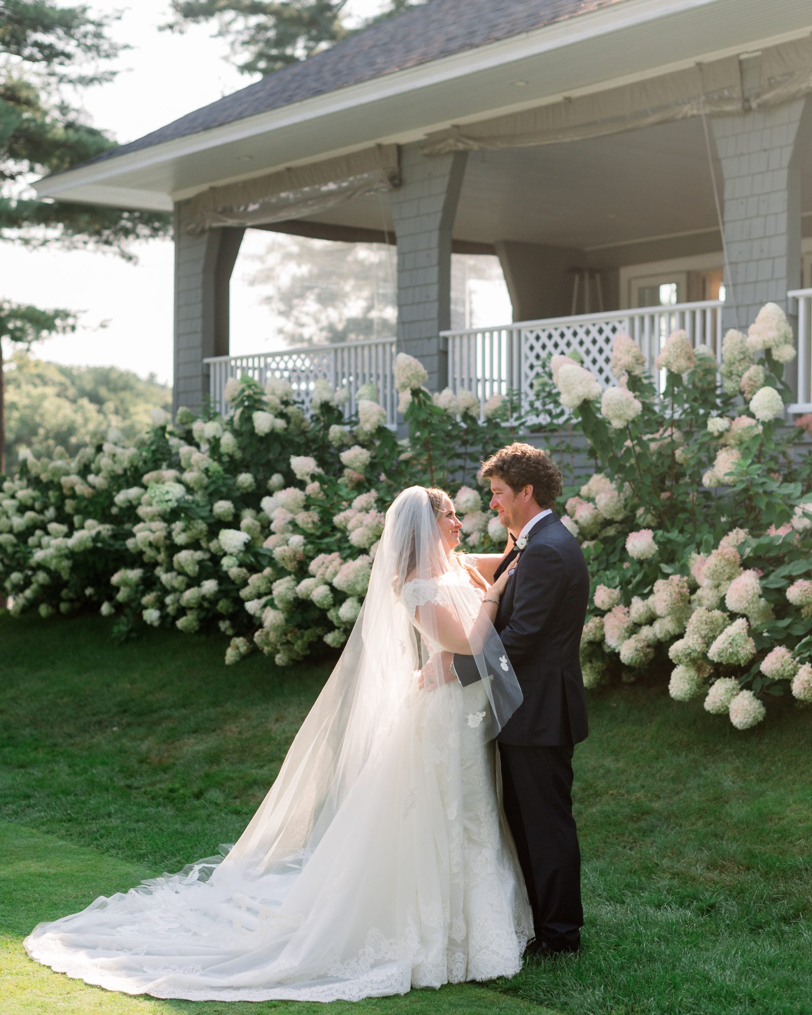 York Golf and Tennis club wedding photos in York Maine. Bride and groom glowing in the sunlight front of the club house.